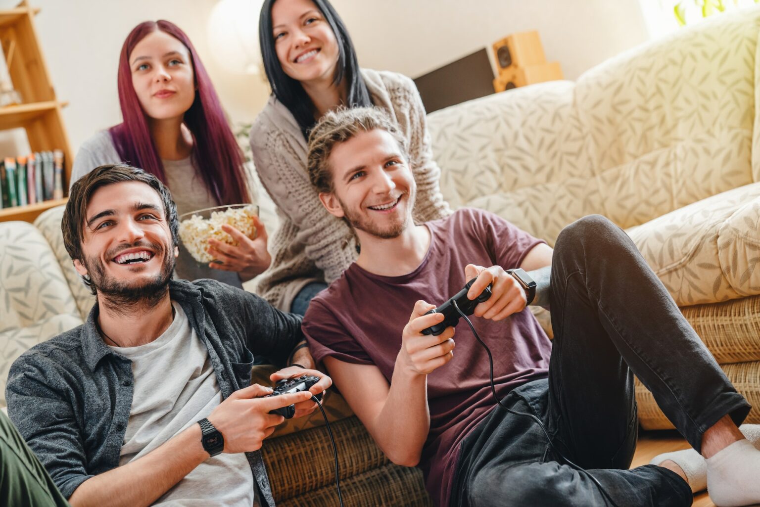 Group of friends playing video games together at home