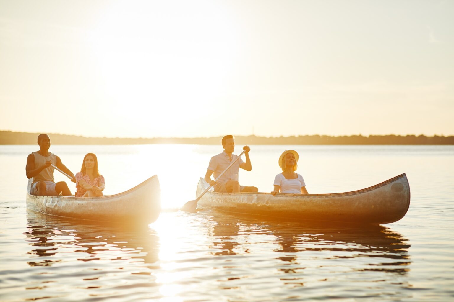 Summer Clubs 10 Smiling group of friends canoeing on a lake in summer
